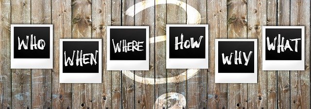 Who what when where why how written on separate Polaroid frames with wooden fence background and a question symbol