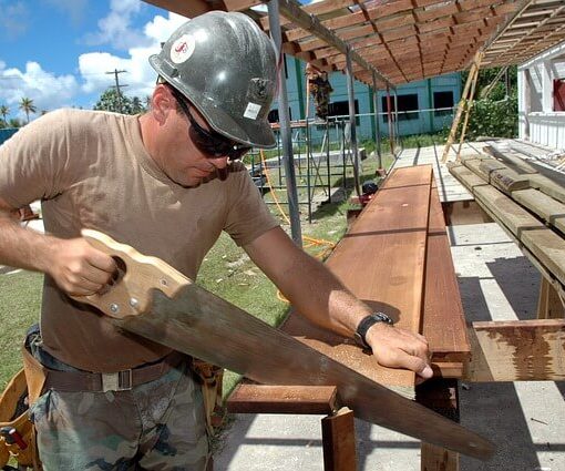 Construction worker sawing wood
